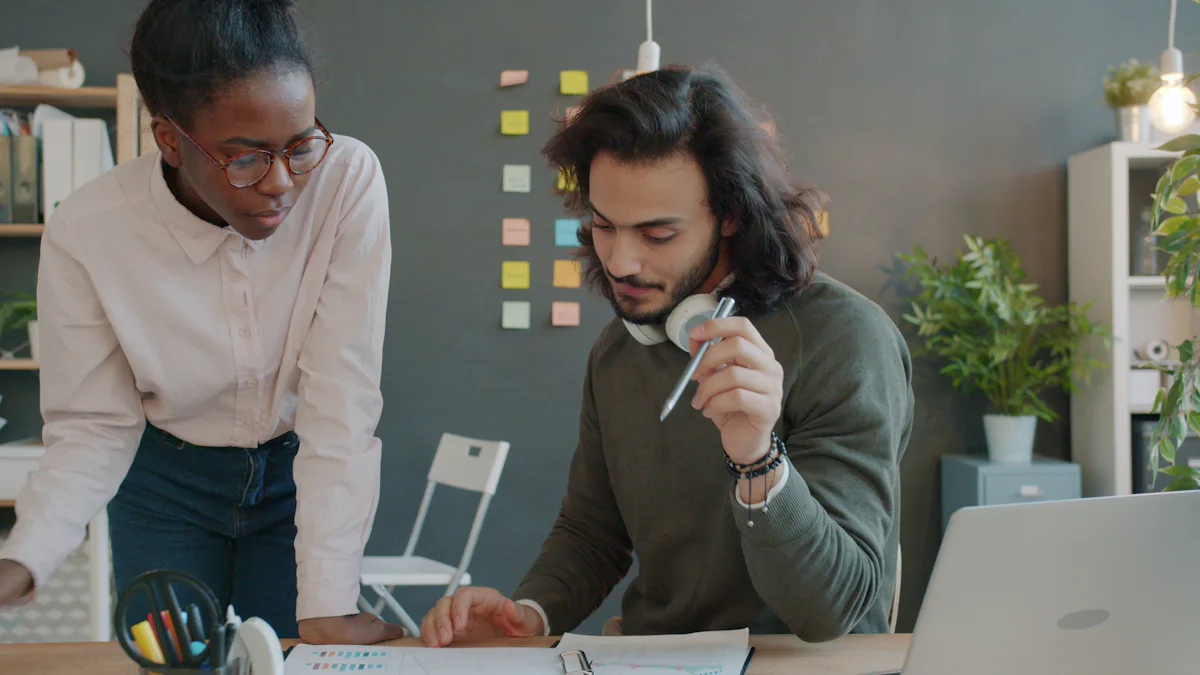 Two colleagues reviewing import documentation on a laptop